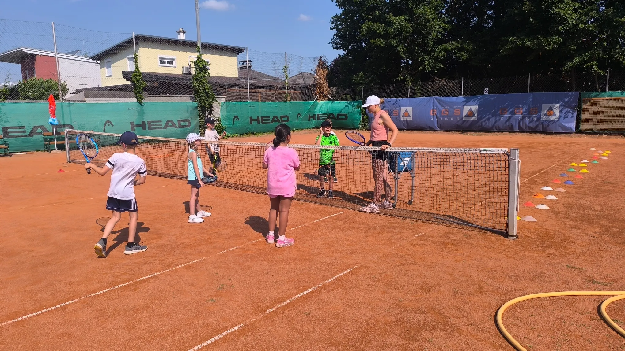 Spielerisches Tennistraining für Kinder mit Anleitung am Netz