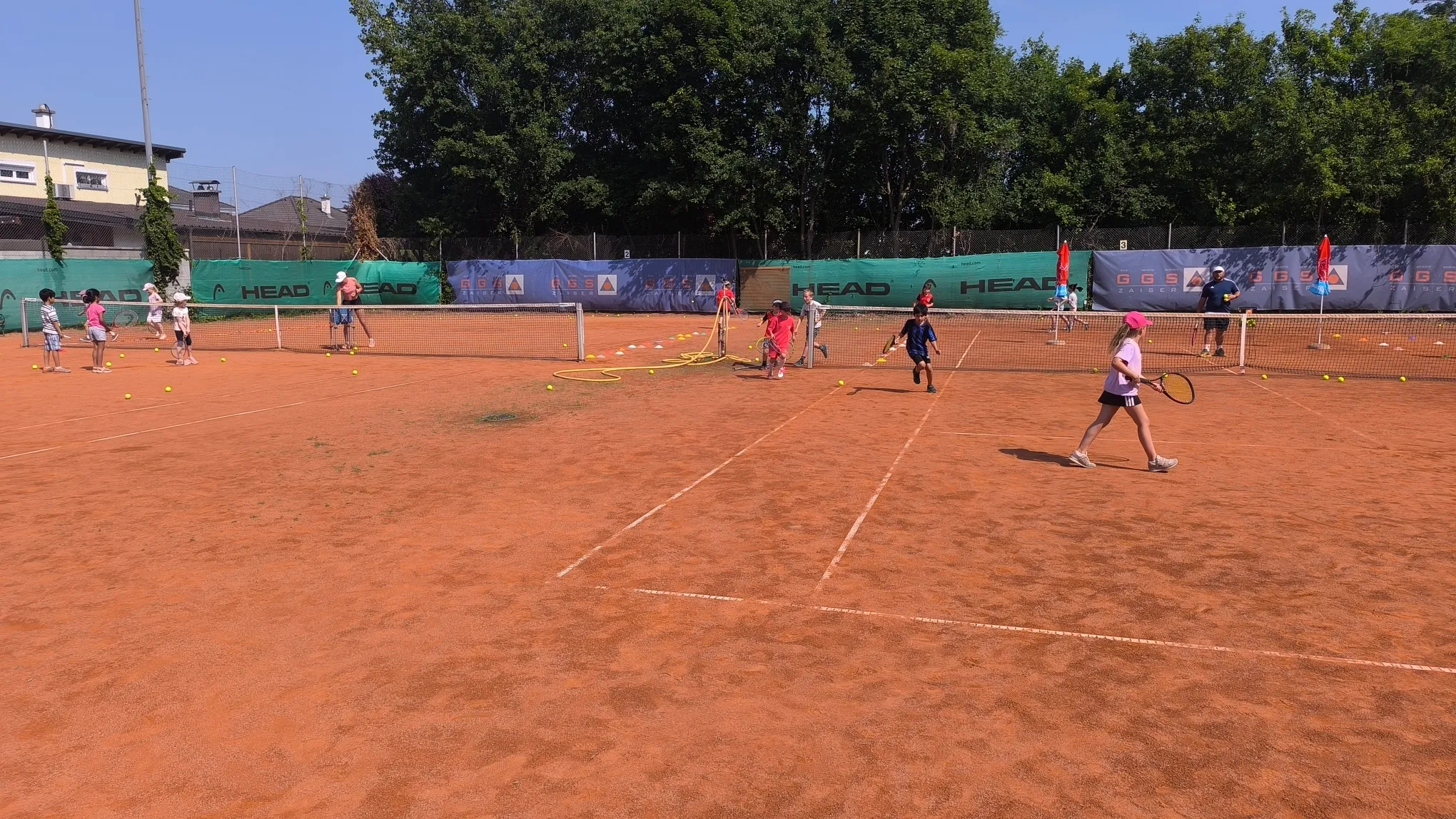 Kinder trainieren an verschiedenen Stationen beim Tenniscamp